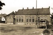 De achterzijde van de Landbouwschool. De hoge paal was in gebruik bij de brandweer voor het ophangen van de brandslangen. Voor meer details klik hier.